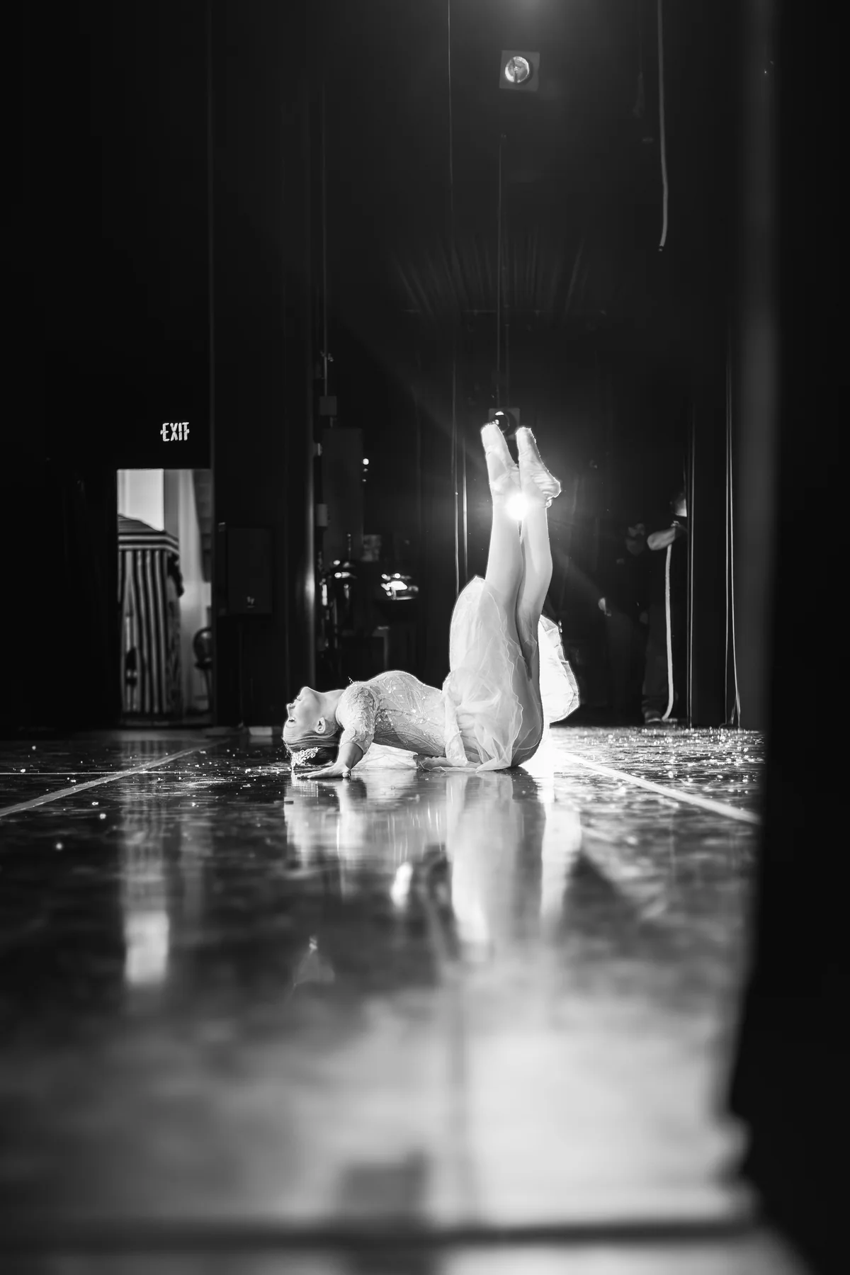 A dancer holding a dramatic pose beneath stage lighting